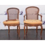 A Louis XVI style beechwood and caned armchair, with padded arms and cabriole legs,
