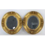 Pair of late 19th century oval carved giltwood picture frames with later mirror plates, 28cm x 25cm