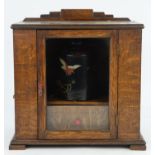 An early 20th century oak smokers cabinet with glazed, hinged door, containing a tobacco box and