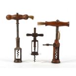 Three corkscrews, two with wooden handles with brush ends, one with rack and pinion action,