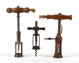 Three corkscrews, two with wooden handles with brush ends, one with rack and pinion action,