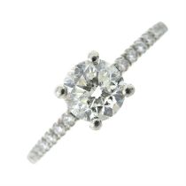 Platinum brilliant-cut diamond ring, with pave-set diamond shoulders.