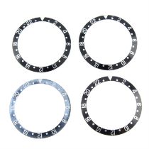 A group of four GMT bezel inserts.