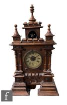 A 19th Century walnut cased cuckoo mantle clock of castellated and turned finial form, circular