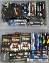 A collection of assorted action and adventure VHS tapes and DVDs, to include Ghostbusters,