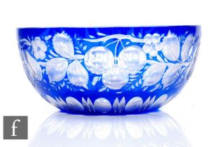 An early 20th Century glass bowl of circular section, cased in blue over clear and flash cut with