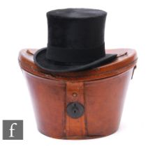 A Victorian black felt top hat by Christy's London, size 6 3/4, with brown leather hat box.