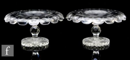 A matched pair of 19th Century clear crystal pedestal tazas, each of shallow circular section with a