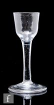 An 18th Century drinking glass circa 1740, the ogee bowl above a slender plain stem, raised to a