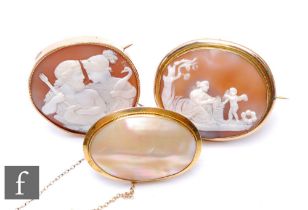 A 9ct mounted oval cameo brooch depicting two classical figures with a further gilt metal example