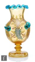 A late 19th Century Harrach continental amber glass vase of footed ovoid form with flared collar