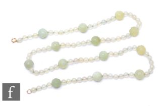 An early 20th Century jade bead necklet detailed with thirteen large carved bead spacers, length