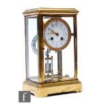 An early 20th Century brass mantel clock with eight day movement striking on a gong, floral swag
