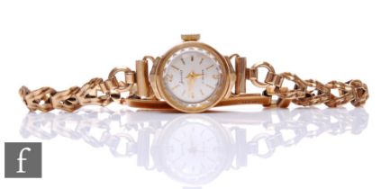 A lady's 9ct hallmarked Accurist manual wind wrist watch, batons to a silvered circular dial and 9ct
