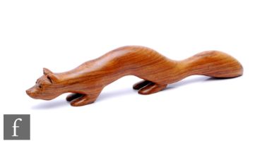 A contemporary studio crafted wooden figure of a stylised fox in crouching pose, signed in