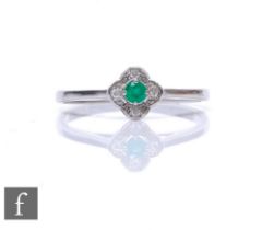 A 10ct white gold emerald and diamond cluster ring, central claw set emerald to a four stone