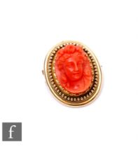 A 19th Century 15ct carved coral cameo portrait of a classical woman within a beaded and rope