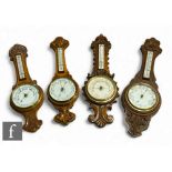 Four various carved oak circular aneroid barometers, each incorporating thermometers, height 88cm,