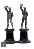 A pair of figures modelled as fencers in standing pose, each with right arm aloft and mounted to a