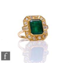 An 18ct hallmarked emerald, diamond and paste set cluster ring, central canted rectangular emerald