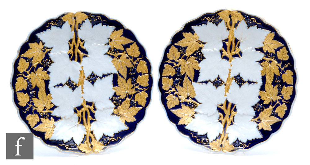 Two 20th Century Meissen plates decorated in relief with leaves and berries against a royal blue