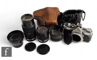 An Olympus OM-2 camera body with three various OM-System lenses, to include f1.8 50mm, f2 24mm, f4