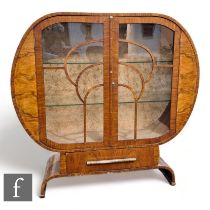 Unknown - An Art Deco walnut veneered cabinet of circular form raised on an arched plinth base,