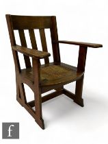 Leonard Wyburd - Liberty & Co. - An 'Athelstan' oak armchair, with rush seat, height 91cm.