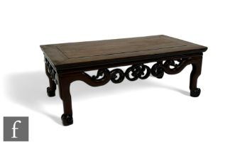 A Chinese Huanghuali style Kang table, with pierced scroll frieze terminating in conforming feet,