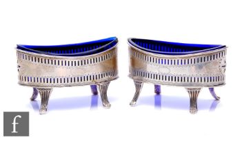 A pair of Edwardian silver boat shaped salts in the Georgian style, each with a blue glass liner