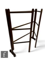 A Victorian floorstanding mahogany double folding clothes horse on shaped and turned end supports,