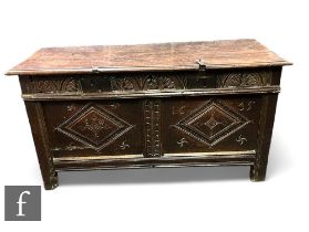 An 18th Century carved oak coffer, triple lozenge panelled front on stiles below a moulded edge top,