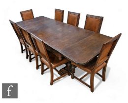 A 1930s Jacobean oak refectory draw leaf dining table, the detailed moulded edge top over a frieze