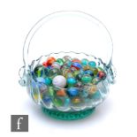 A collection of marbles and a glass basket.