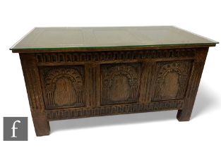 A 17th Century style carved oak triple panelled coffer, arched front enclosed by a lid, height