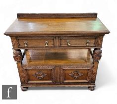 A 1930s Jacobean style carved oak two tier buffet, the moulded edge top over two frieze drawers