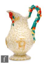 A Clarice Cliff flower jug in Celtic Harvest, the footed baluster form body with high arched