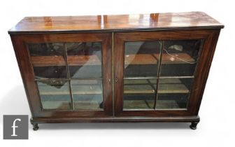 An Edwardian mahogany bookcase of narrow proportions enclosed by a pair of bar glazed doors below