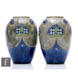 A pair of early 20th Century Royal Doulton stoneware vases of ovoid form, relief decorated with