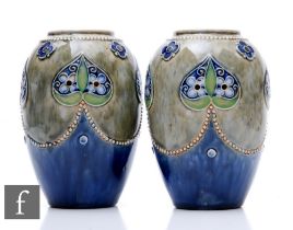 A pair of early 20th Century Royal Doulton stoneware vases of ovoid form, relief decorated with