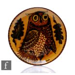 A later 20th Century slip ware dish, the shallow circular well slip decorated with a stylised owl