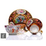 A 19th Century English porcelain tea cup and saucer decorated with panels of flowers against a