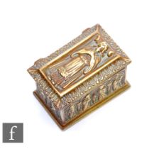 An ecclesiastical style brass trinket box decorated with medieval style figures and modelled as a