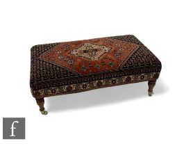 A large Victorian style stool on turned beech legs, upholstered in a Caucasian rug pattern, width