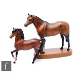 A later 20th Century Beswick model of a chestnut racehorse mounted to an oval wooden plinth,