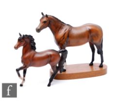 A later 20th Century Beswick model of a chestnut racehorse mounted to an oval wooden plinth,