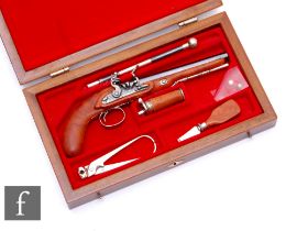 A 1970s or later cased miniature flintlock pistol with silver mounted tools, in a small red plush