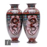A pair of Chinese cloisonne vases, each of ovoid pedestal form, decorated with phoenix and dragon,