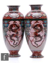 A pair of Chinese cloisonne vases, each of ovoid pedestal form, decorated with phoenix and dragon,