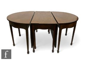 A George III mahogany D end extending dining table, the plain top over an undulating frieze with